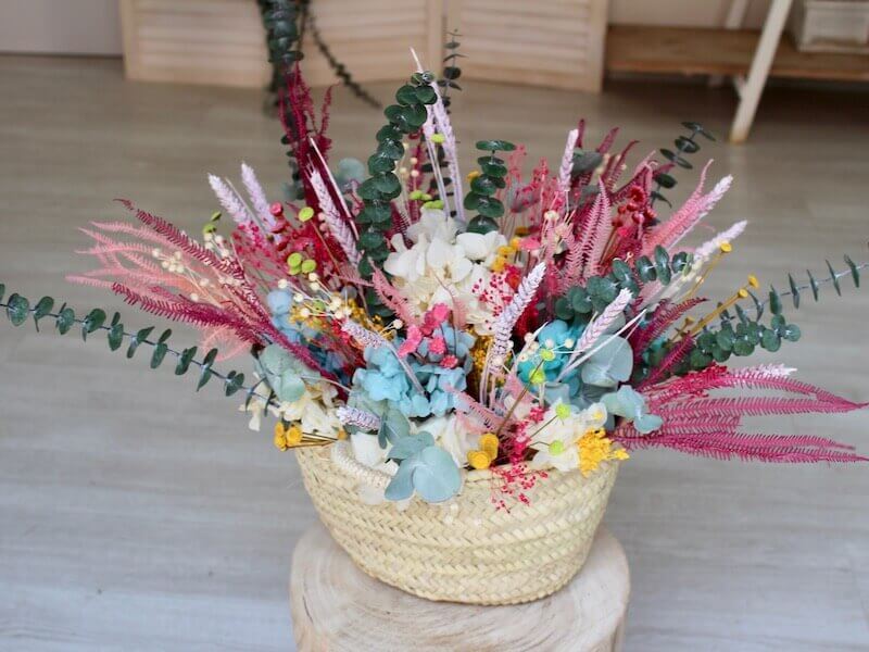 Cesta de mimbre decorada con flores secas y preservadas en tonos rosas -  Trencadissa Art floral